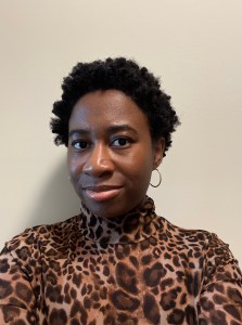 A Black woman with a short fro in a cheetah print turtleneck