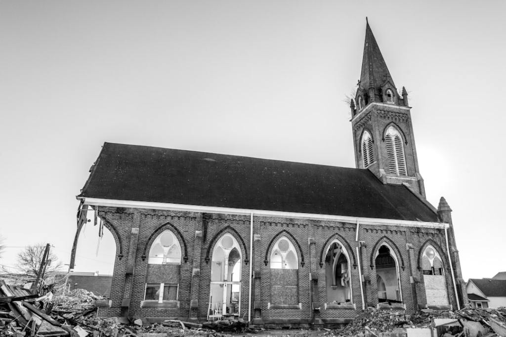 A black and white photo of a church falling apart